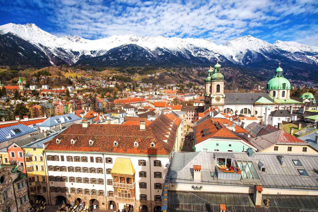 Panoramic view of Innsbruck's cityscape featuring the iconic Golden Roof, domed cathedrals, and a backdrop of the majestic Nordkette mountains
